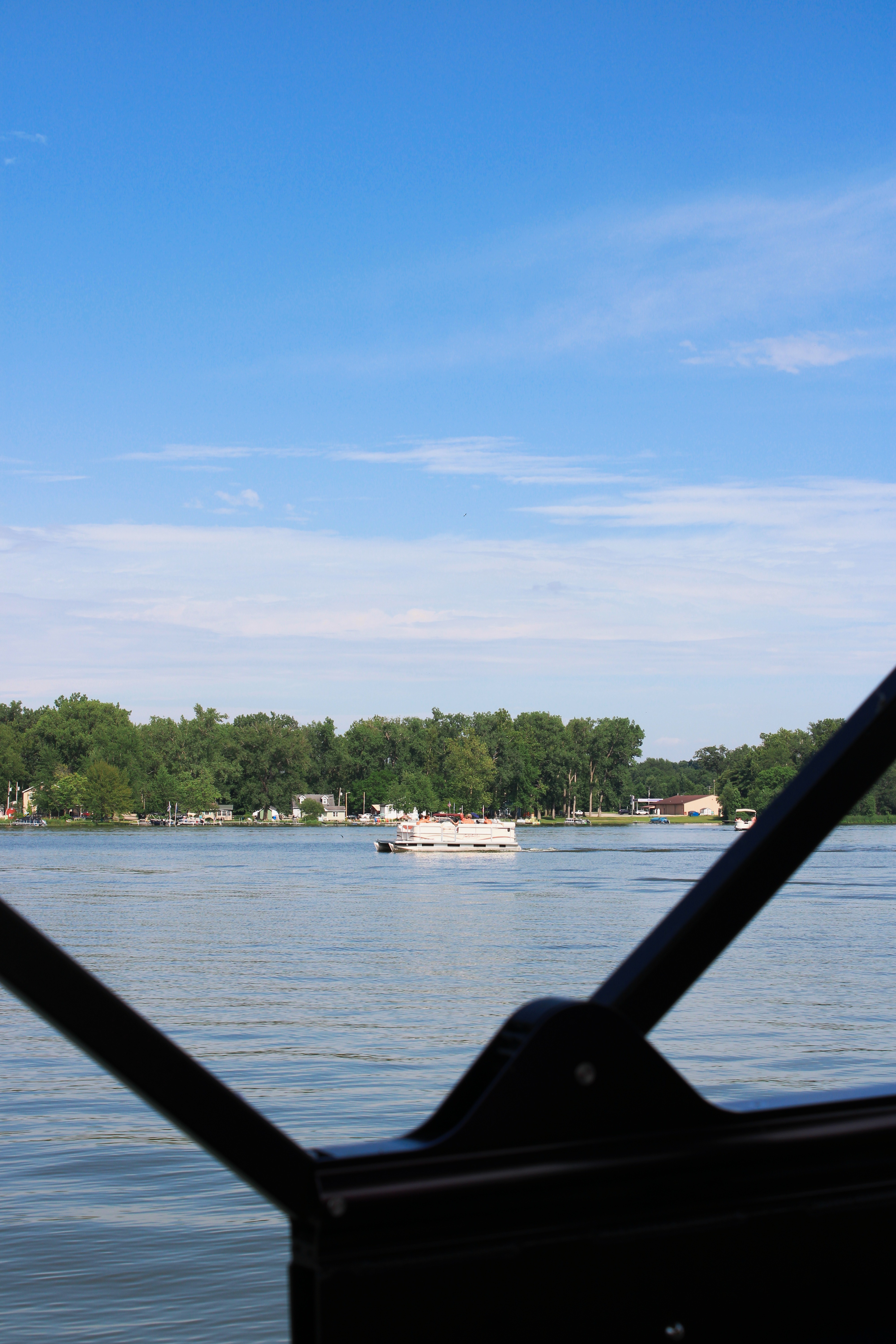 A pontoon boat floating on a serene lake in Indiana, ideal for a vacation rental experience.